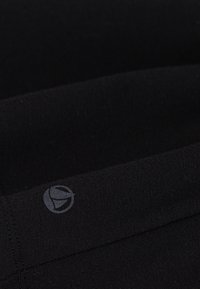 Tessuto nero con una consistenza morbida; presenta un logo sottile grigio; il design è semplice e minimale, sottolineando la qualità del materiale.