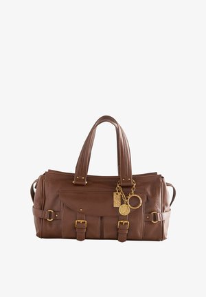 Brown leather handbag with two short handles, gold hardware accents, front pocket flap, and decorative keychain. Features buckle details.