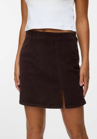 Gonna mini in corduroy marrone con uno spacco frontale; presenta una superficie testurizzata, un design aderente e un orlo che termina sopra il ginocchio.