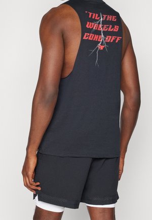 Homme portant un débardeur noir avec un texte rouge "TIL THE WHEELS COME OFF" et un graphique d'éclair dans le dos, associé à un short noir.