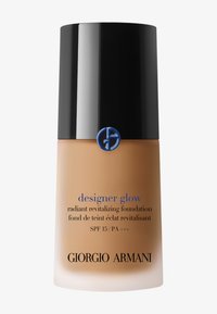 Fond de teint dans un flacon en verre givré avec un capuchon noir. Présente un logo bleu et un texte indiquant un SPF 15. La couleur est un ton beige chaud.