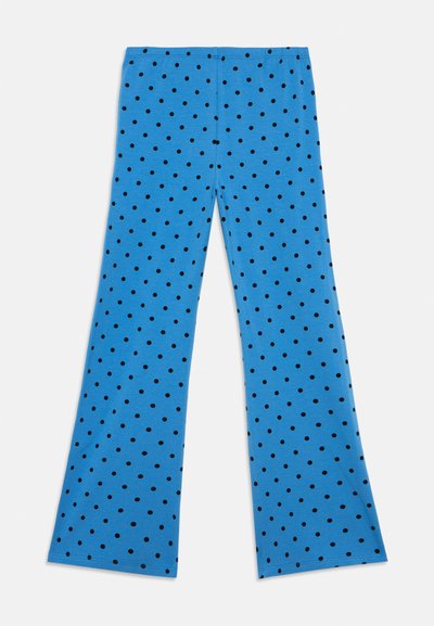 Modré nohavice s širokými nohavicami a čiernymi bodkami, s elastickým pásom, rozložené na bielom pozadí.