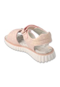 Różowe sandały z teksturowaną cholewką, regulowanym paskiem i wyścielonym wnętrzem. Posiadają masywną białą gumową podeszwę i wzorzystą wkładkę.