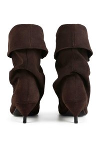 Stivaletti alla caviglia in suede marrone con un design morbido, punte a punta e tacco conico; presentano una parte superiore arrotolata che sovrappone la tomaia.