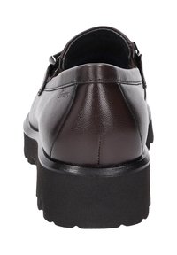 Bruine leren schoen met een gladde afwerking, met een lage hak en een zwarte rubberen zool. De achterkant toont stiksels en heeft een ronde vorm.