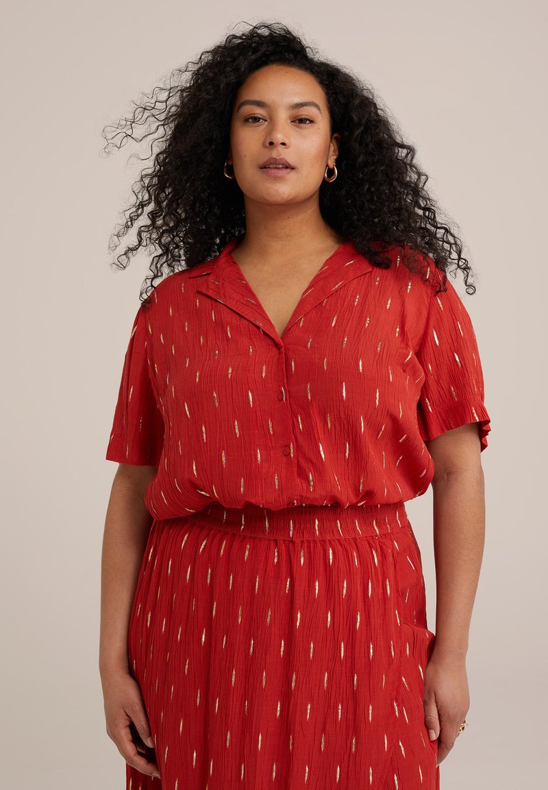 Vestido rojo con mangas cortas, parte delantera abotonada y cintura elástica. Presenta patrones verticales en dorado y blanco, confeccionado en una tela ligera.