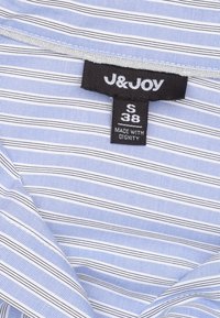 Blauw-wit gestreept overhemd met een label waarop "J&JOY" staat, maat S, en "MADE WITH DIGNITY" erop gedrukt. Katoenen materiaal, met kraag.