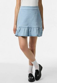 Šviesiai mėlyna džinsinė sijonas su plat�ėjančia apatine dalimi, su raukšlėmis apačioje. Lygi tekstūra su klasikinio kirpimo, iki kelių pabaiga.