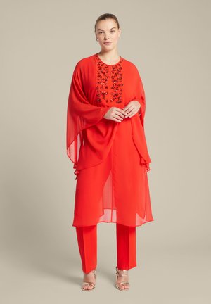 Rode chiffon outfit met een lange tuniek met geborduurde versieringen en bijpassende broek. De stof is lichtgewicht met een vloeiende uitstraling.