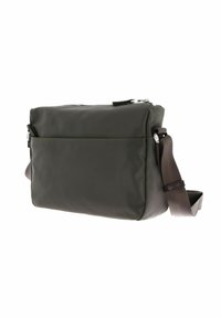 Sac bandoulière vert foncé en matériau lisse et résistant à l'eau. Il dispose d'une fermeture éclair, d'une bandoulière réglable et d'une poche zippée à l'avant.