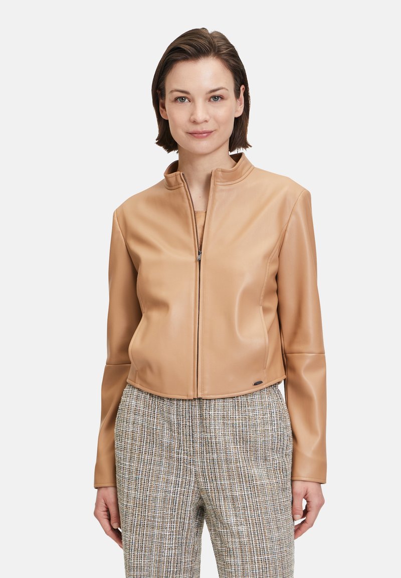 Camel kleurige faux leren cropped jas met een staande kraag en een rits aan de voorkant. Getextureerde grijze plaid broek. Minimalistische hardware details.