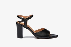 Sandal de tacón alto de cuero negro con punta abierta, tira en el tobillo y tacón ancho; presenta una textura suave y un diseño minimalista.