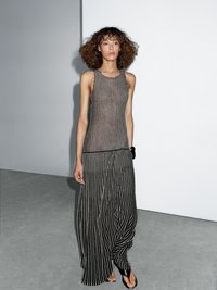 Top a righe e gonna palazzo in nero e beige. Tessuto testurizzato con righe verticali, caratterizzato da una vestibilità ampia e uno stile casual.