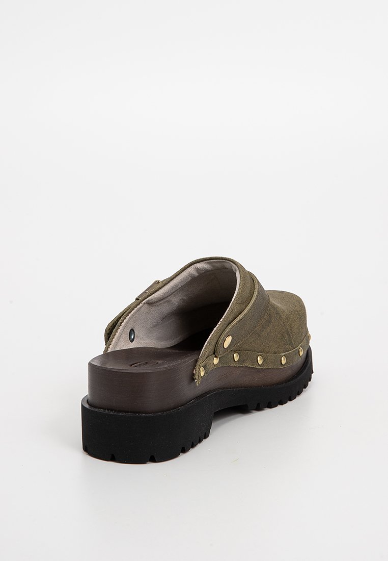 Scarpa slip-on in suede verde con retro arrotondato, suola in gomma e borchie dorate lungo il lato. Fodera interna morbida per il comfort.