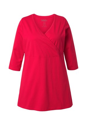 Rote, aus Baumwolle gefertigte Tunika im Wickelstil mit V-Ausschnitt und dreiviertel Ärmeln. Verfügt über ein tailliertes Oberteil und einen ausgestellten Saum. Weiche Textur.