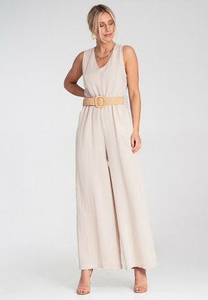 Beige, ärmelloser Jumpsuit aus weichem Stoff, mit einem V-Ausschnitt und einem breiten Bund, der mit einem Strohbelt cinched ist. Glatte Textur mit breiten, fließenden Beinen.