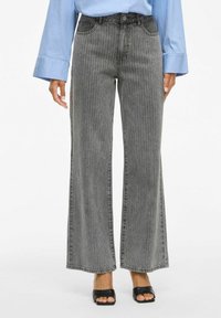 Jeans de pierna ancha y cintura alta en una suave tela gris con rayas verticales, con un diseño clásico de cinco bolsillos y lazos para cinturón.
