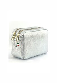 Zilveren metalen cosmetica tas met twee gouden ritssluitingen, rechthoekige vorm, gestructureerd oppervlak en een klein driekleurig Italiaans vlagdetail.