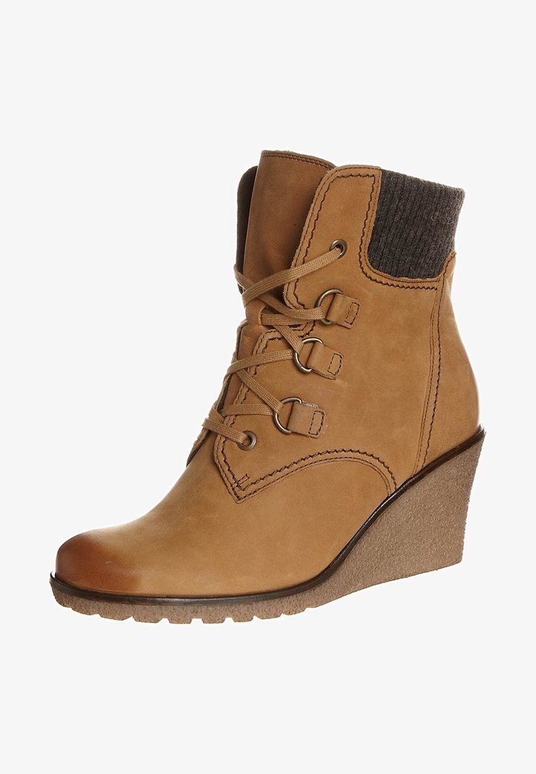 Bottine compensée en cuir camel avec bout rond, laçage à l'avant et bordure en tricot gris. Semelle en caoutchouc texturée pour une bonne adhérence.