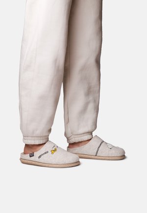 Gray felt slippers with open backs, featuring black line drawings and yellow accent. Worn with cream-colored, tapered sweatpants.