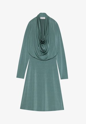 Zöldes tónusú, cowl-nyakú ruha, hosszú ujjal és bővülő sziluettel. Puha, sima textúra, finom fényességgel.