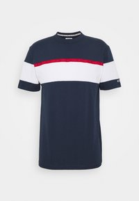 Námorně modré tričko s krátkým rukávem s bílým horizontálním pruhovaním přes prsa a červeným páskem s nápisem "Tommy Jeans" nad ním.