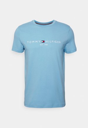 Lichtblauwe katoenen t-shirt met ronde hals, met witte tekst "TOMMY HILFIGER EST. 1985" en een logo in contrasterende kleuren.