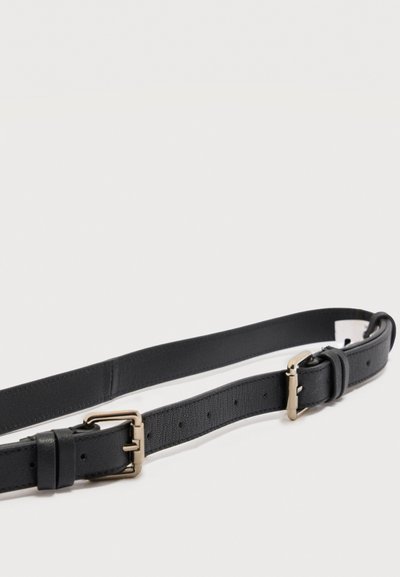 Μαύρη δερμάτινη ζώνη με διπλές ασημένιες μεταλλικές αγκράφες, απλωμένη επίπεδα σε λευκό φόντο.