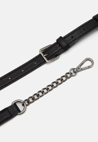 Czarny skórzany pasek z teksturowanym wykończeniem, srebrna metalowa klamra oraz odpinany łańcuch z zapięciem na sprężynę.