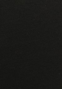 Czarna prążkowana tkanina o teksturowanej powierzchni z pionowymi liniami. Materiał wydaje się miękki i lekko elastyczny. Brak wyraźnych wzorów lub akcentów.