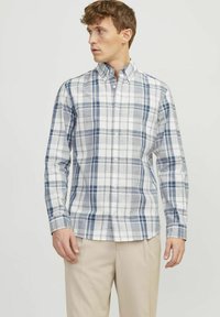 Camisa de hombre de botones en una mezcla de algodón; presenta un patrón de cuadros azul y blanco, mangas largas, cuello puntiagudo y bolsillo en el pecho.