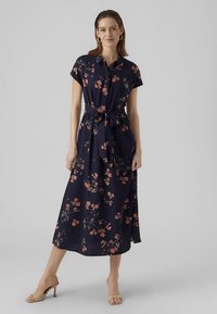 Tamsiai mėlyna maxi suknelė su trumpomis rankovėmis ir diržu ties liemeniu. Papuošta rožinėmis ir žaliomis gėlių raštais bei laisvai krintančia siluetu.