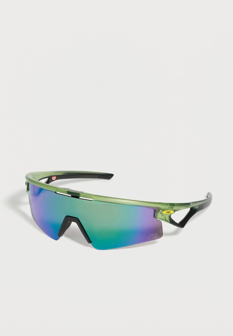 Αθλητικά γυαλιά ηλίου με πράσινο πλαίσιο, περιμετρικούς φακούς με καθρέφτη σε μπλε-μωβ απόχρωση και μαύρη γέφυρα μύτης σε λευκό φόντο.
