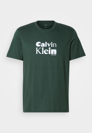 Dunkelgrünes T-Shirt mit kurzen Ärmeln und Rundhalsausschnitt, mit weißem "Calvin Klein"-Logo-Text, der vorne zentriert ist.