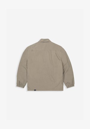 Lichtbeige jack met lange mouwen, kraag, elastische manchetten en een rechte zoom. Heeft een logo-label nabij de onderste linkerkant.