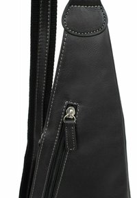 Zaino in pelle nera con cuciture bianche a contrasto, dotato di una cerniera esposta e una forma snella per una conservazione compatta.