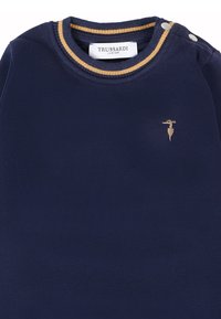 Golfino navy blue Trussardi Junior con collo a girocollo a strisce beige, due bottoni argentati sulla spalla e piccolo logo ricamato beige sul petto.