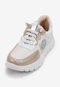 Zapatillas deportivas con parte superior de cuero blanco y beige claro, detalles plateados, texturizados y cordones grises. Suela redondeada con un ligero plataforma.
