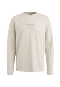 Langeærmet beige t-shirt lavet af bomuld, med et trykt logo i midten. Rund hals og afslappet pasform, med sideslidser i sømmen.