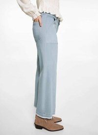 Svetlomodré široké džínsy s rozstrapkaným lemom, bočnými vreckami a hladkou textúrou, skombinované s hnedými členkovými čižmami, zobrazené zo strany.