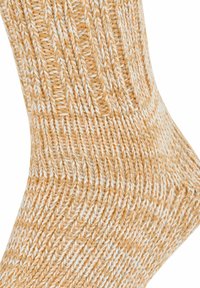 Skarpety dziane z miękkiej włóczki, charakteryzujące się żeberkową fakturą. Kolor to połączenie jasnego pomarańczu z bielą, z zygzakowatym wzorem na całej powierzchni.