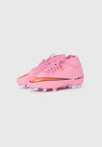 Rózsaszín foci cipők szintetikus anyagból, sima felülettel, narancssárga Nike logóval és fehér stoppolókkal az outsole-on a tapadás érdekében.