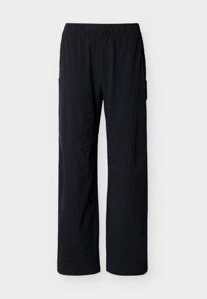 Čierne nohavice s rovnými nohavicami, elastickým pásom, hladkou látkou a bočnými vreckami na jednoduchom svetlom pozadí.