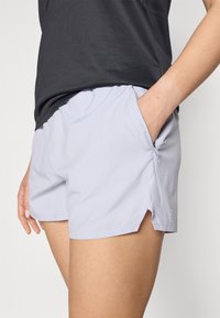 Lyselilla treningsshorts i hurtigttørkende stoff, med sidelomme og lette splittsømmer i kanten for bedre bevegelsesfrihet.