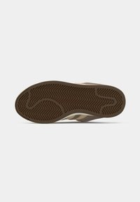 Εξωτερική σόλα γυάλινου παπουτσιού με σχέδιο ανάγλυφης ελαστικής ζιγκ-ζαγκ. Καφέ και εκρού χρώματα με υφή φινιρίσματος και σχεδιασμό υποστήριξης της καμάρας.