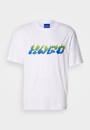 Bílé tričko s krátkým rukávem, na kterém je modrý a zelený plamenový styl textu "HUGO" přes hruď, kulatý výstřih a modrá vnitřní etiketa.