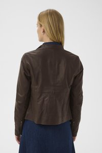 Giacca in pelle marrone con un design aderente, cuciture sulle spalle e sottili dettagli con zip sulle maniche. Finitura testurizzata, lunghezza cropped.