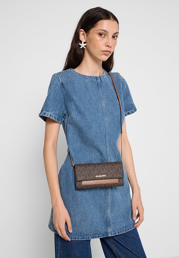 Braune gemusterte Umhängetasche mit goldenen Beschlägen, glatter Textur und abnehmbarem Kettenriemen; vor einem hellen Hintergrund platziert.