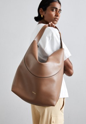 Borsa hobo in pelle marrone con una texture liscia, parte superiore curva e cuciture a contrasto. Presenta un logo discreto in oro.