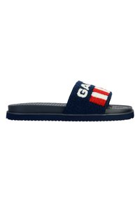 Navy blue slide sandal with a textured, plush strap featuring white and red accents, textured sole, and sleek, minimalist design.